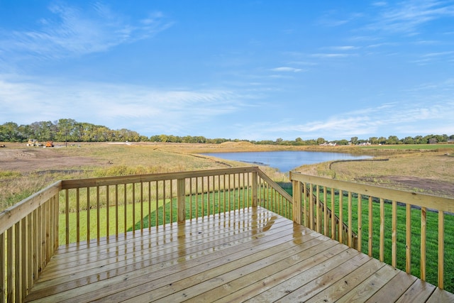 wooden deck featuring a rural view, a water view, and a lawn