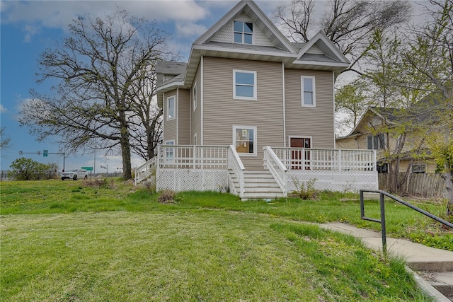 view of front of home with a deck and a front lawn