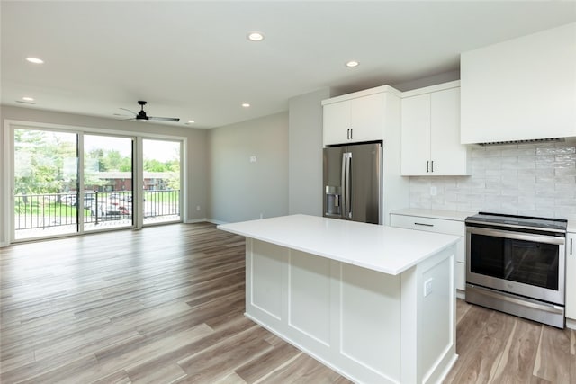 kitchen with white cabinetry, backsplash, appliances with stainless steel finishes, a kitchen island, and light hardwood / wood-style floors