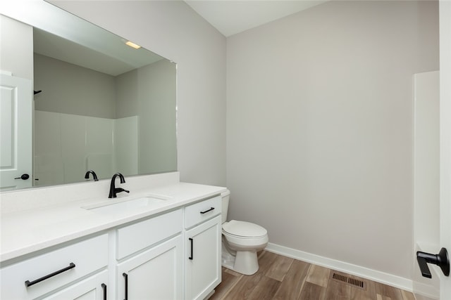 bathroom with vanity, hardwood / wood-style flooring, and toilet