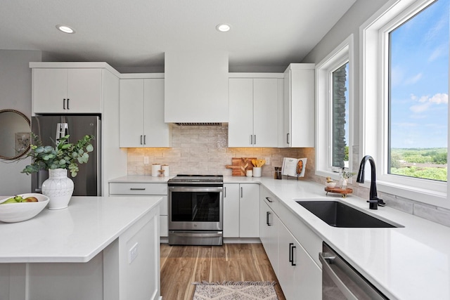 2712 Fleur Dr, Des Moines, IA 50321 - kitchen featuring stainless steel appliances, a sink, recessed lighting, light countertops, and tasteful backsplash