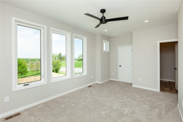 carpeted spare room featuring ceiling fan