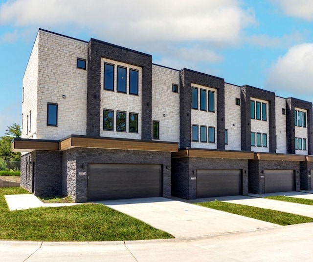 view of property featuring a garage, driveway, and a front yard
