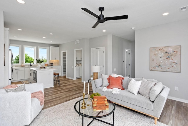2738 Fleur Dr Unit 23, Des Moines, IA 50321 - living area with light wood-style flooring, a ceiling fan, recessed lighting, and baseboards