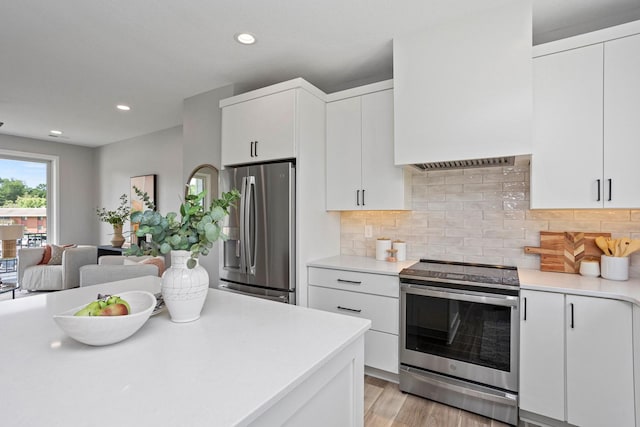 2738 Fleur Dr Unit 23, Des Moines, IA 50321 - kitchen featuring appliances with stainless steel finishes, light countertops, white cabinetry, decorative backsplash, and recessed lighting