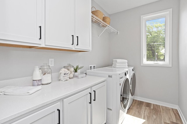 2738 Fleur Dr Unit 23, Des Moines, IA 50321 - clothes washing area with cabinet space, washer and dryer, light wood-style flooring, and baseboards