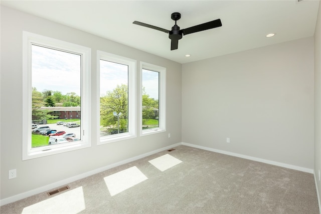 carpeted spare room featuring ceiling fan