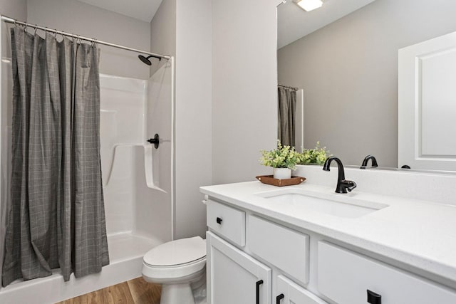 2714 Fleur Dr Unit 11, Des Moines, IA 50321 - full bath featuring toilet, a shower with shower curtain, wood finished floors, and vanity