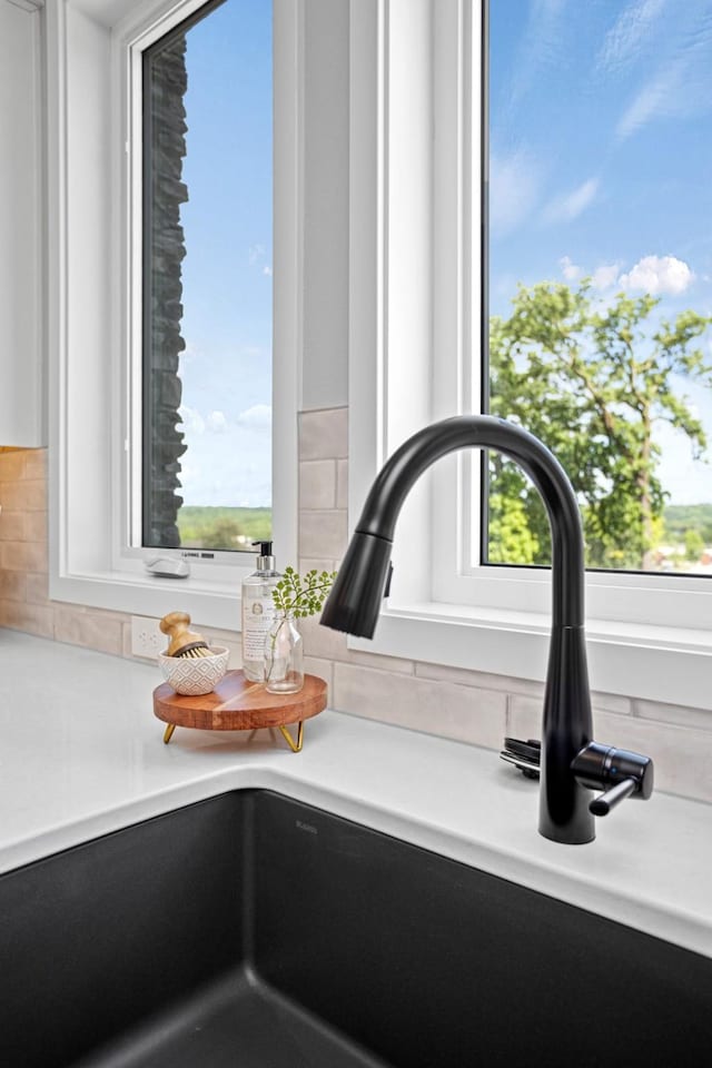 2714 Fleur Dr Unit 11, Des Moines, IA 50321 - kitchen view of a sink, light countertops, and backsplash