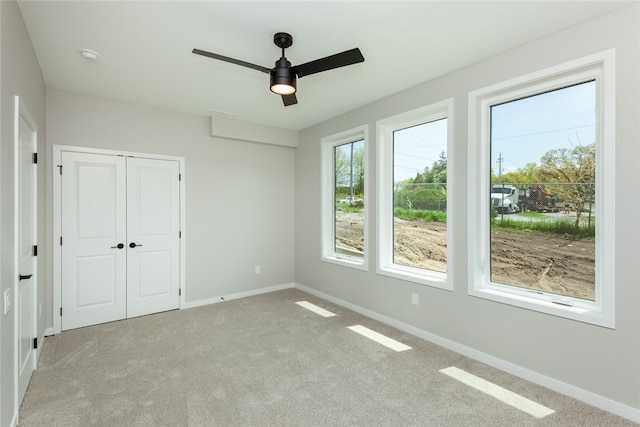 unfurnished bedroom with a closet, carpet floors, and ceiling fan