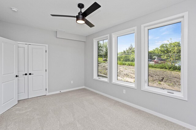 2716 Fleur Dr Unit 12, Des Moines, IA 50321 - unfurnished bedroom featuring baseboards, carpet floors, a closet, and a ceiling fan