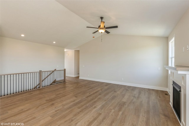 unfurnished living room featuring light wood-type flooring, vaulted ceiling, and ceiling fan