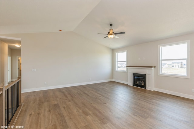 unfurnished living room with ceiling fan, lofted ceiling, and light wood-type flooring