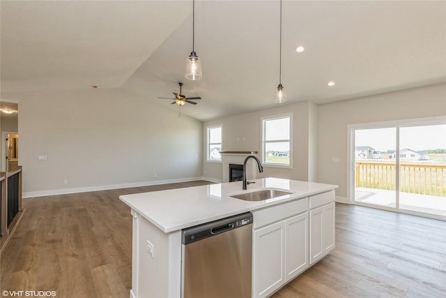 kitchen featuring sink, hanging light fixtures, stainless steel dishwasher, a kitchen island with sink, and white cabinets