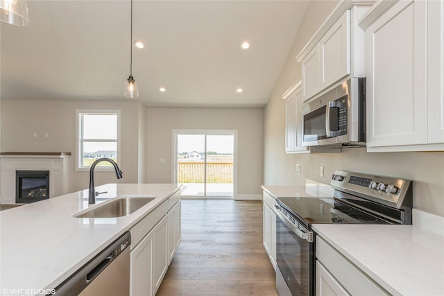 kitchen with a wealth of natural light, hanging light fixtures, sink, and appliances with stainless steel finishes