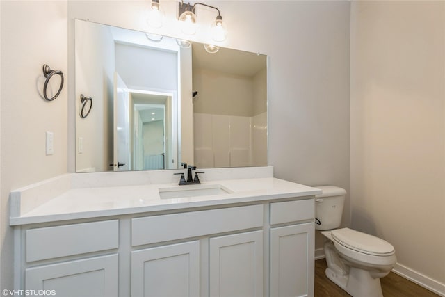 bathroom with hardwood / wood-style flooring, vanity, toilet, and walk in shower