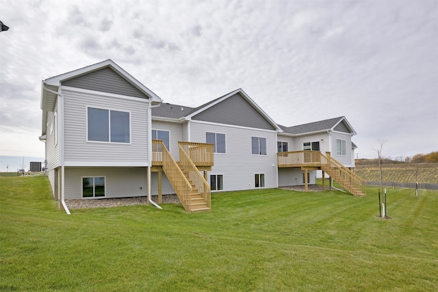 rear view of property featuring a deck, central AC unit, and a lawn