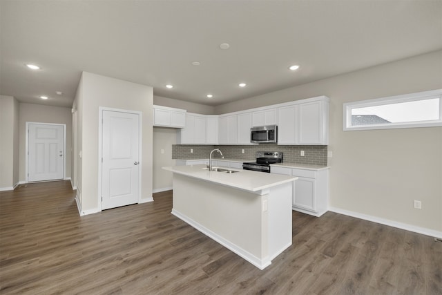 kitchen featuring appliances with stainless steel finishes, white cabinetry, a kitchen island with sink, and dark wood-type flooring