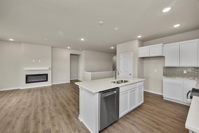 kitchen featuring dishwasher, a center island with sink, sink, white cabinetry, and light hardwood / wood-style floors