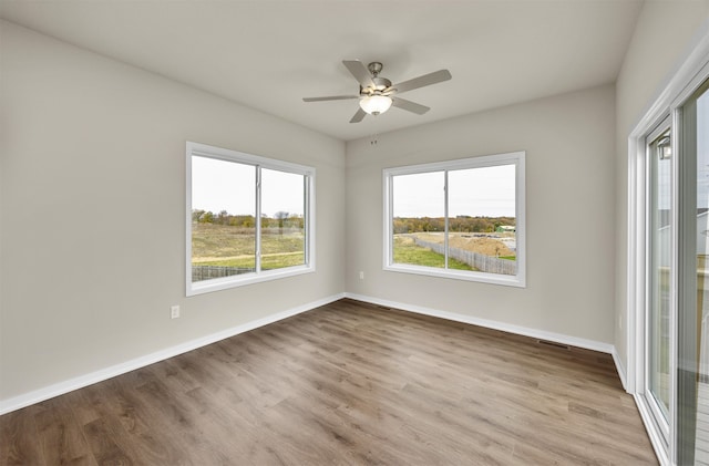 empty room with light hardwood / wood-style flooring and ceiling fan