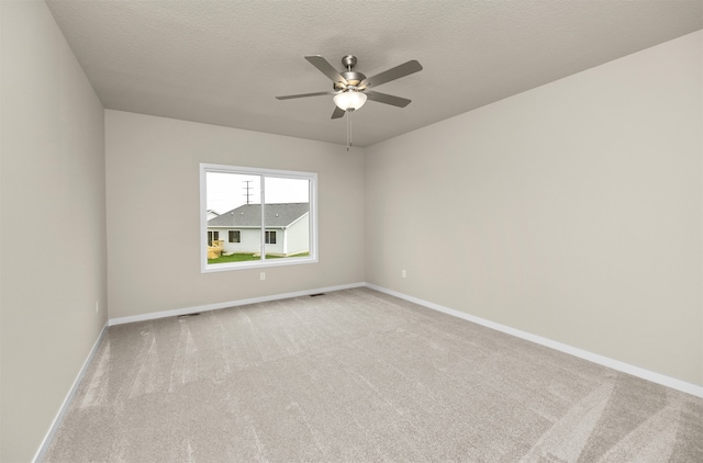 unfurnished room featuring light carpet, a textured ceiling, and ceiling fan