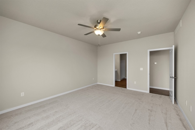 unfurnished bedroom with light carpet, a textured ceiling, and ceiling fan