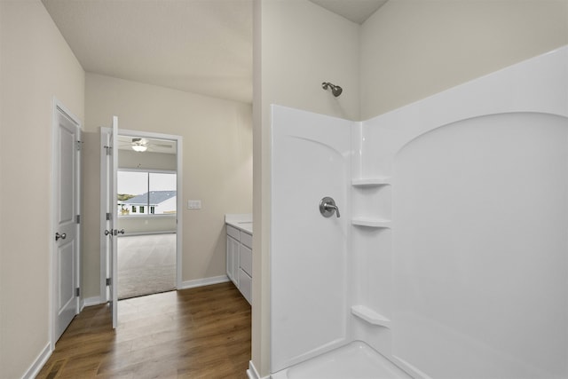 bathroom with vanity, ceiling fan, walk in shower, and hardwood / wood-style floors