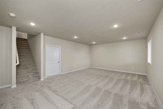 carpeted empty room featuring a textured ceiling