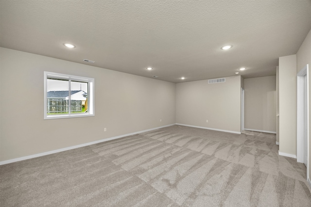 carpeted empty room featuring a textured ceiling