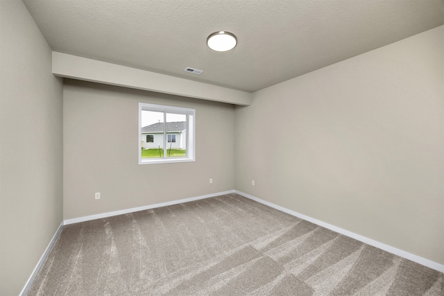 carpeted spare room with a textured ceiling