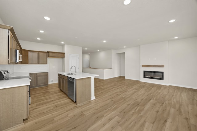 kitchen featuring a center island with sink, sink, appliances with stainless steel finishes, and light hardwood / wood-style floors