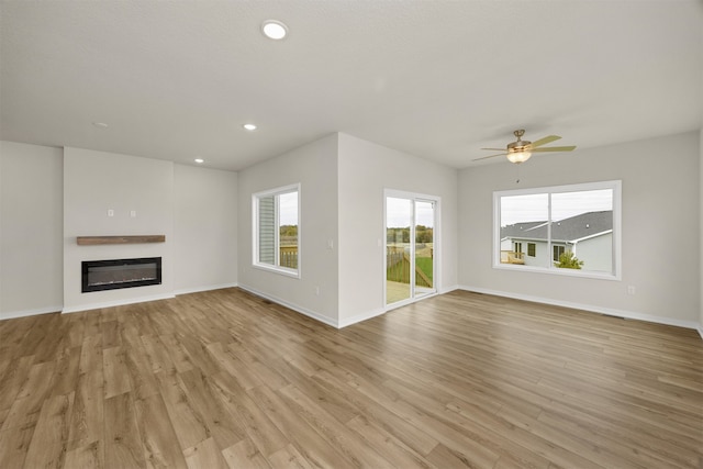 unfurnished living room with light hardwood / wood-style flooring and ceiling fan