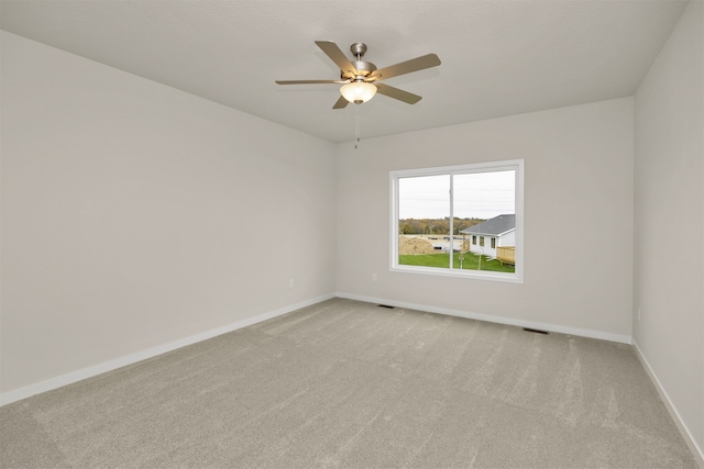 spare room featuring light carpet and ceiling fan