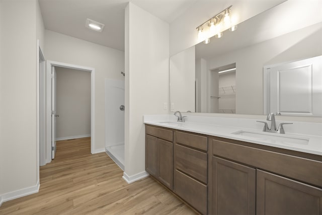 bathroom with vanity, a shower, and hardwood / wood-style flooring