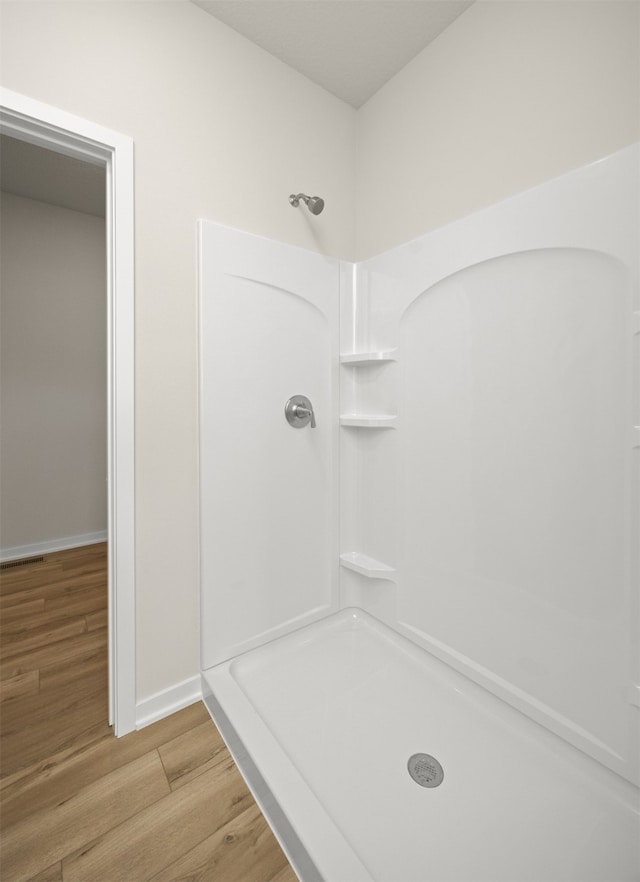 bathroom featuring a shower and wood-type flooring