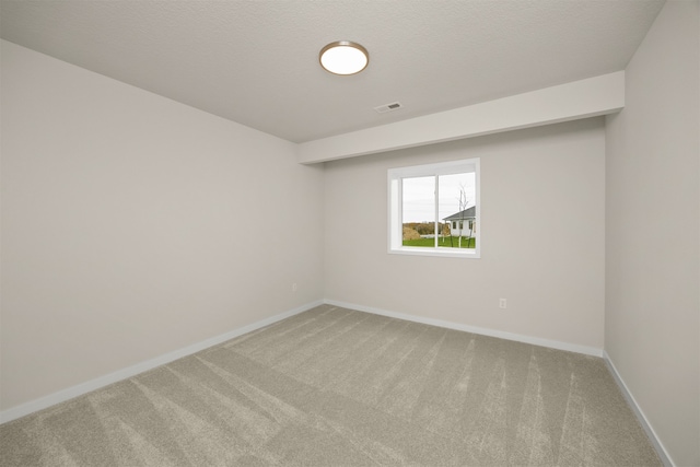 carpeted spare room with a textured ceiling