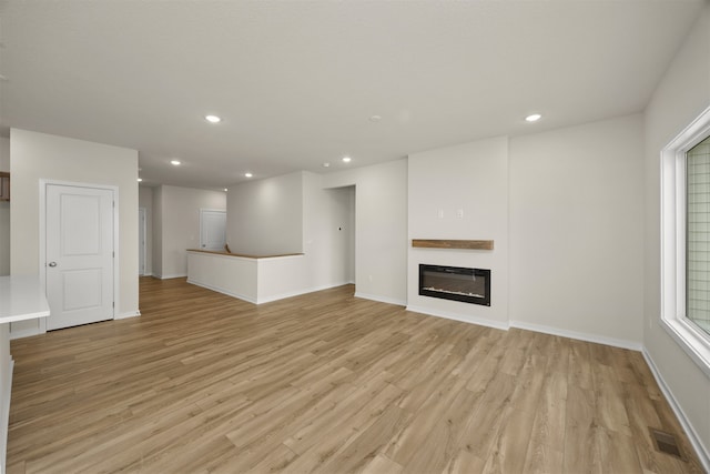 unfurnished living room with light hardwood / wood-style floors and heating unit