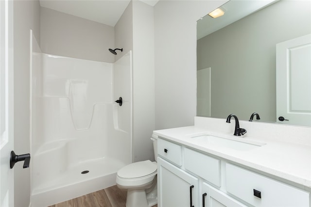 bathroom with walk in shower, hardwood / wood-style floors, vanity, and toilet