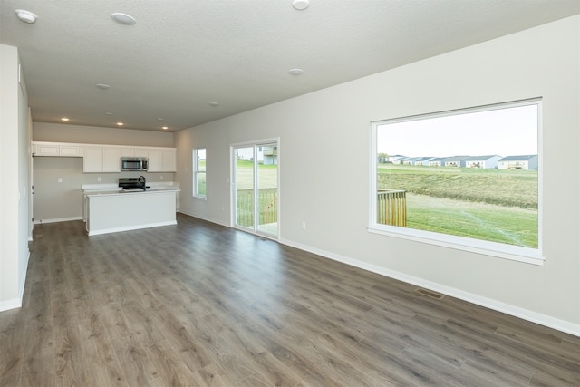 unfurnished living room with a textured ceiling and hardwood / wood-style flooring