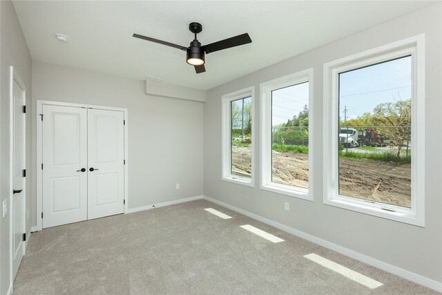 unfurnished bedroom featuring a closet, ceiling fan, and carpet floors