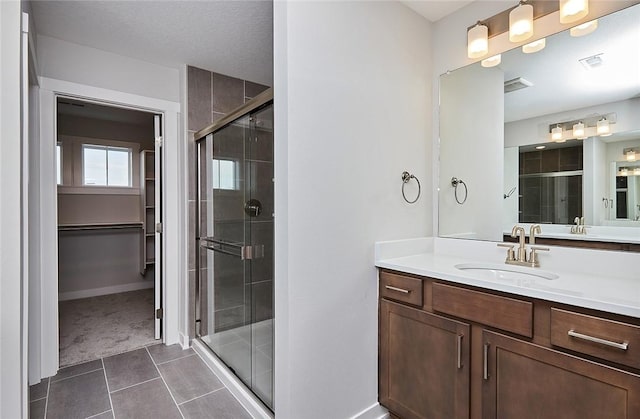 bathroom with tile patterned floors, a shower stall, visible vents, and vanity