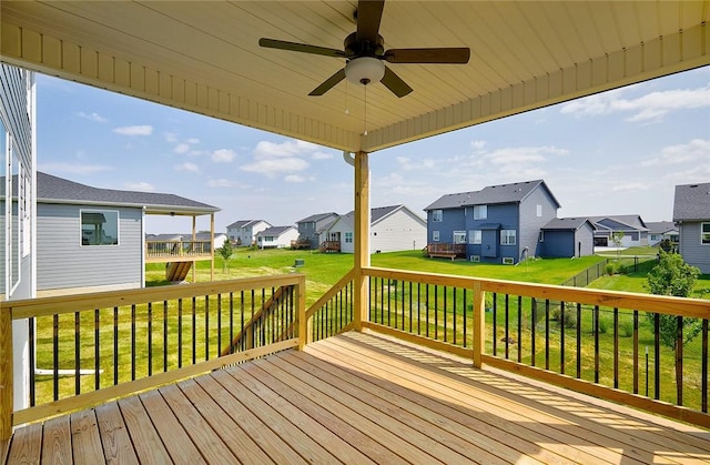 wooden terrace featuring a residential view, a ceiling fan, and a yard