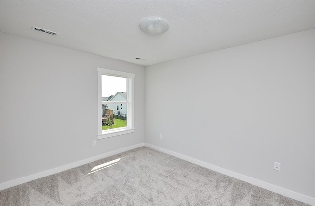 unfurnished room featuring carpet, visible vents, and baseboards