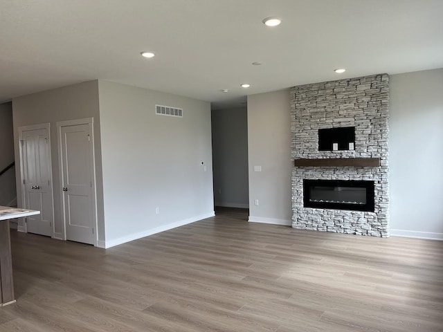 unfurnished living room featuring recessed lighting, baseboards, visible vents, and light wood finished floors