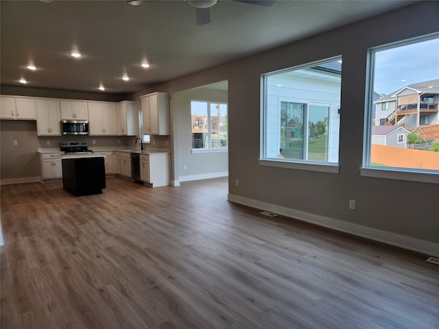 kitchen with ceiling fan, hardwood / wood-style floors, white cabinets, sink, and black dishwasher