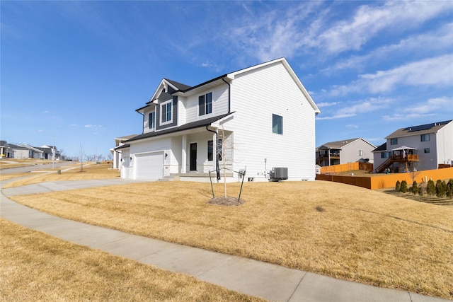 view of front property featuring cooling unit, a garage, and a front lawn