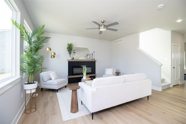 living room featuring ceiling fan and light hardwood / wood-style floors