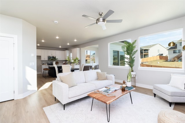 living room featuring ceiling fan and light hardwood / wood-style flooring