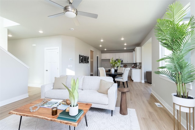 living room featuring ceiling fan and light wood-type flooring