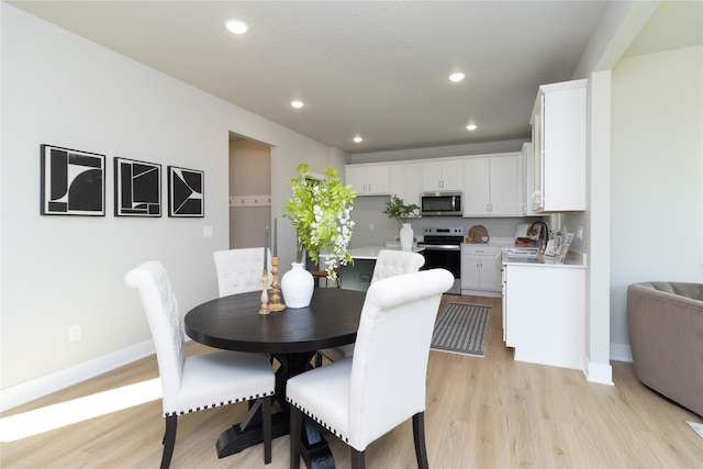 dining room with sink and light hardwood / wood-style floors